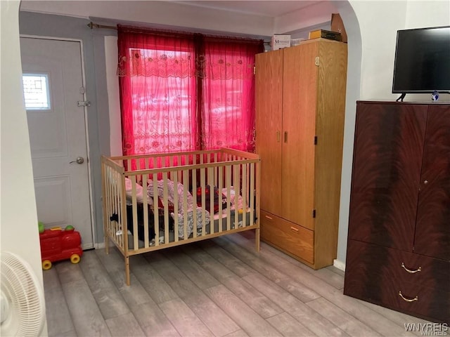 428 Tonawanda St, Buffalo, NY 14207 - bedroom with arched walkways, wood finished floors, a nursery area, and baseboards