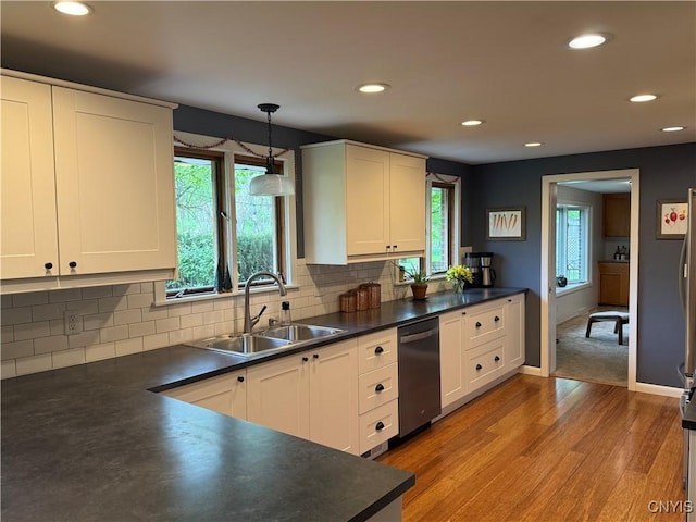 kitchen featuring a sink, stainless steel dishwasher, dark countertops, light wood-type flooring, and recessed lighting