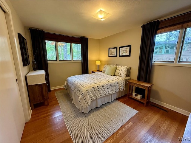 bedroom featuring baseboards and wood finished floors