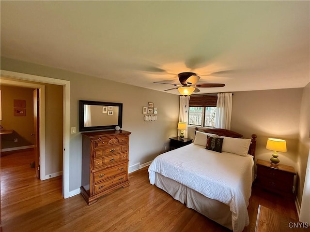 bedroom featuring wood finished floors, baseboards, and ceiling fan