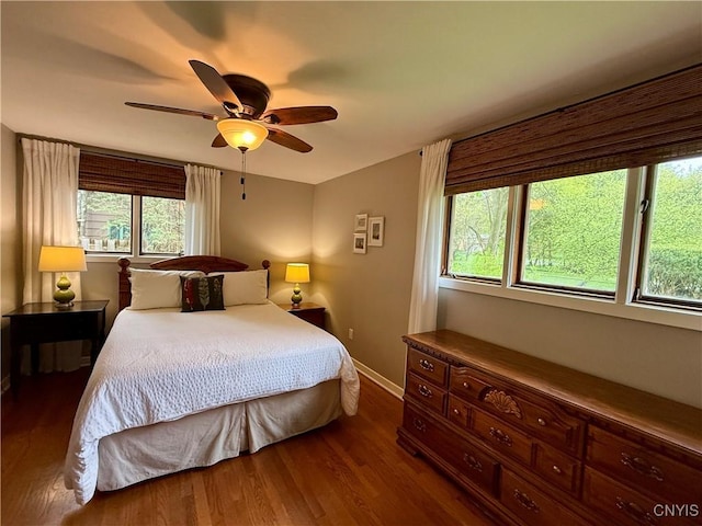 bedroom with wood finished floors, baseboards, and ceiling fan