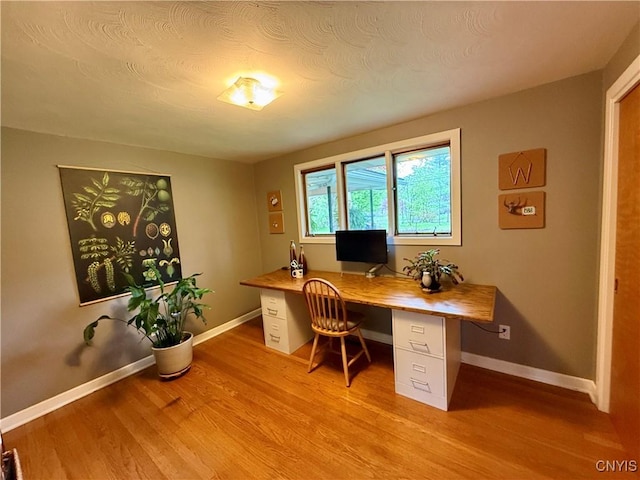 office space with light wood-type flooring and baseboards