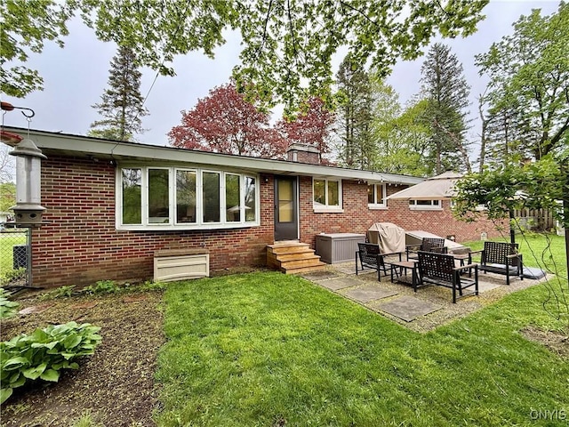 rear view of house featuring brick siding, a chimney, a patio area, and entry steps
