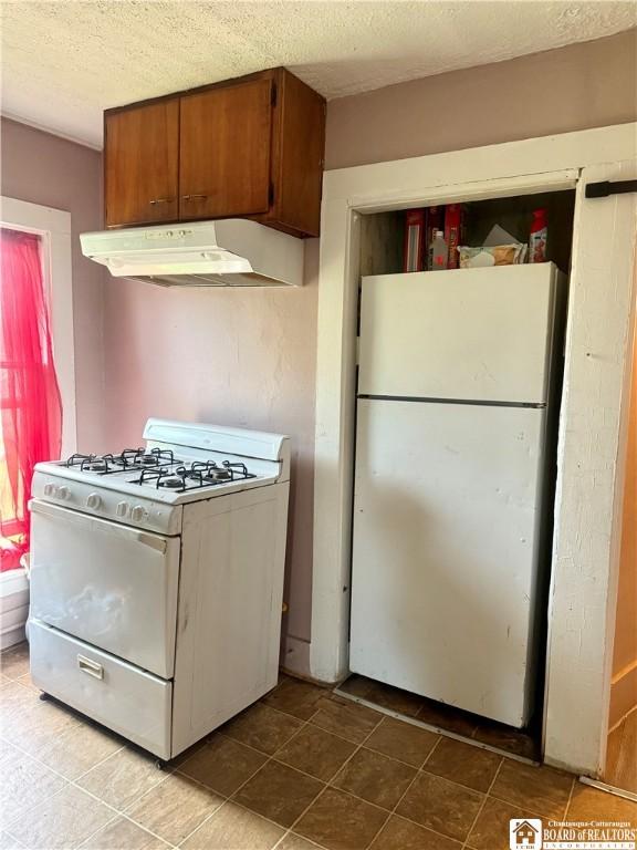 99 King St, Dunkirk-City, NY 14048 - kitchen with white appliances, under cabinet range hood, a textured ceiling, and brown cabinetry