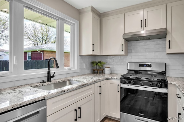 kitchen featuring appliances with stainless steel finishes, under cabinet range hood, a sink, and plenty of natural light