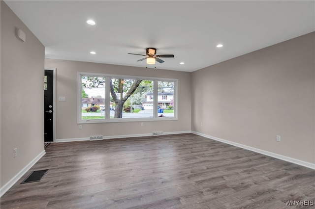 unfurnished room featuring ceiling fan, recessed lighting, wood finished floors, and baseboards