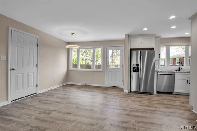 kitchen with appliances with stainless steel finishes, baseboards, light stone countertops, white cabinetry, and recessed lighting