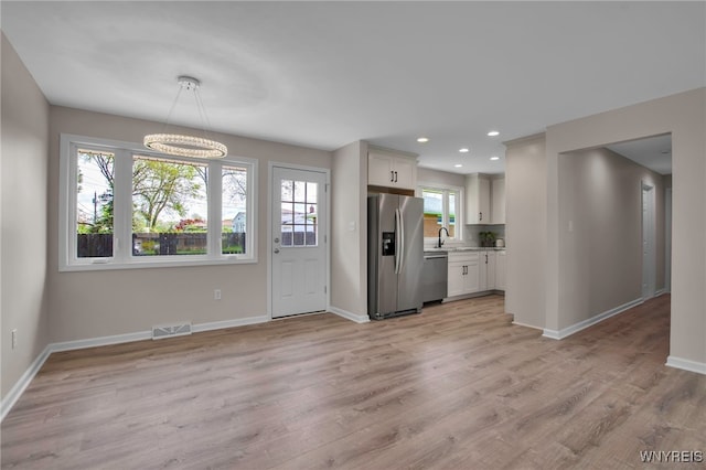kitchen featuring appliances with stainless steel finishes, baseboards, light wood-style floors, a chandelier, and recessed lighting