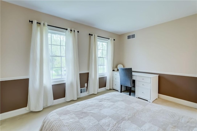 bedroom featuring light carpet, baseboards, and a desk