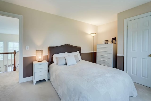 bedroom featuring light carpet and baseboards