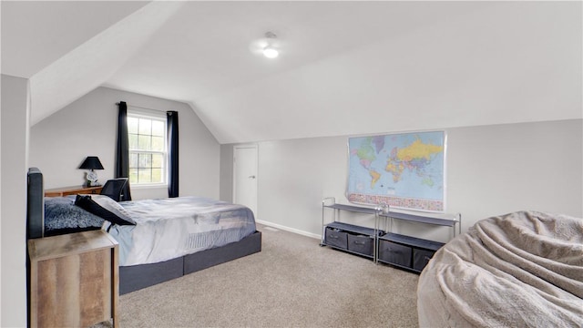 bedroom with carpet floors, lofted ceiling, and baseboards