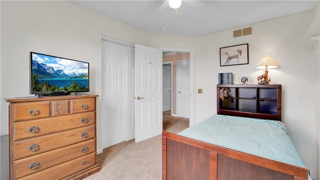 bedroom featuring light colored carpet, a ceiling fan, and a closet