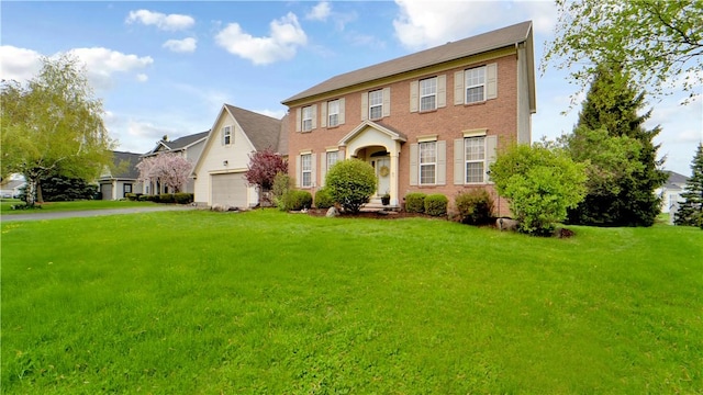 view of front of property with a front lawn, an attached garage, asphalt driveway, and brick siding