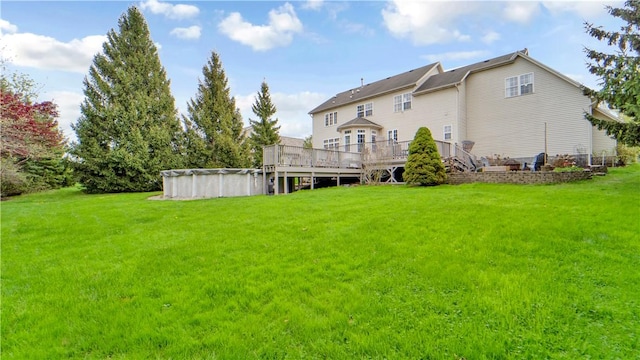 back of house featuring a deck, a lawn, and a covered pool