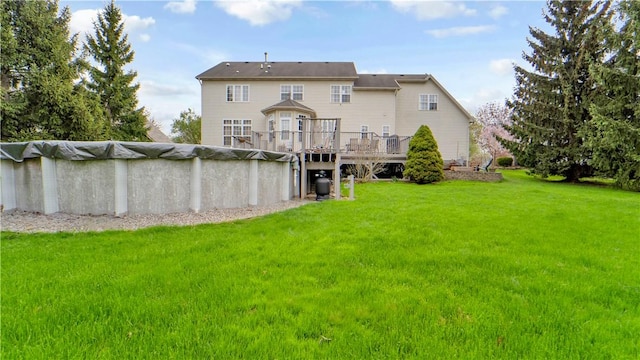 rear view of property with a deck, a lawn, and a covered pool