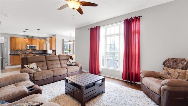 living area with a ceiling fan, light wood-style floors, baseboards, and recessed lighting