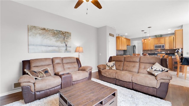 living room featuring baseboards, a ceiling fan, wood finished floors, and recessed lighting