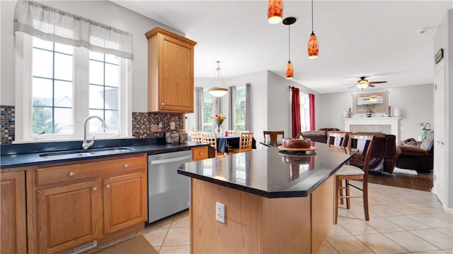kitchen with dishwasher, a sink, a breakfast bar, light tile patterned flooring, and decorative backsplash