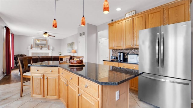 kitchen with freestanding refrigerator, light tile patterned flooring, a kitchen island, a ceiling fan, and open floor plan