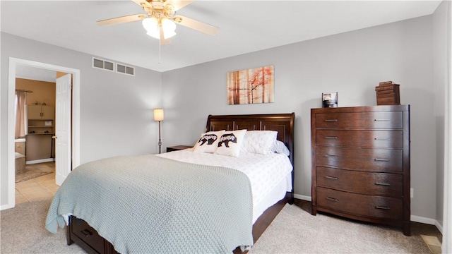 bedroom featuring light carpet, baseboards, ceiling fan, and connected bathroom