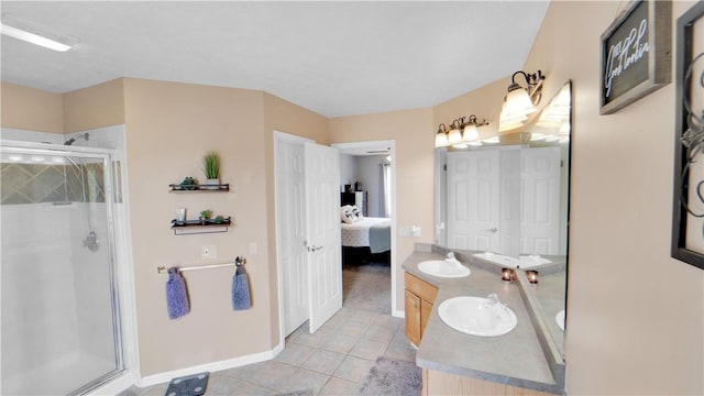 bathroom with a stall shower, baseboards, tile patterned flooring, double vanity, and connected bathroom