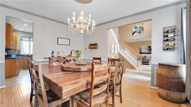 dining area featuring crown molding, stairs, light wood-style flooring, a chandelier, and baseboards