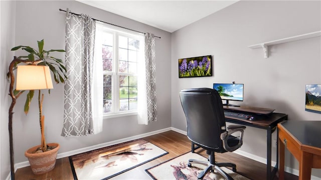 office space featuring plenty of natural light, wood finished floors, and baseboards