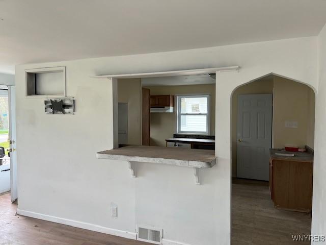 1026 93rd St, Niagara Falls, NY 14304 - kitchen featuring a breakfast bar area, wood finished floors, plenty of natural light, and baseboards