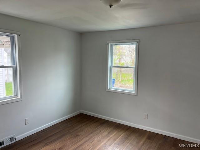 1026 93rd St, Niagara Falls, NY 14304 - empty room with plenty of natural light, baseboards, and wood finished floors