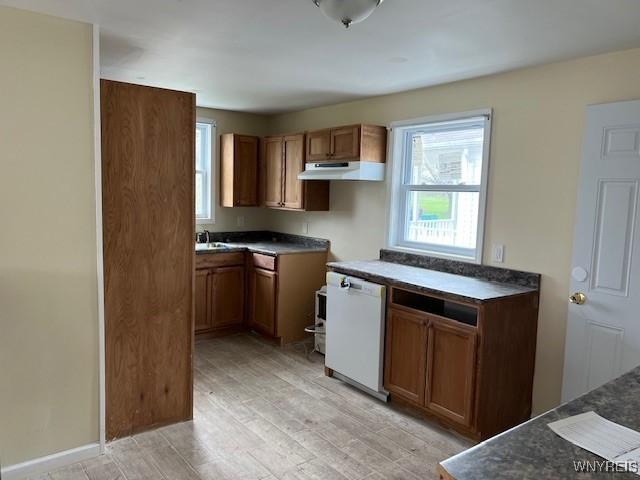 1026 93rd St, Niagara Falls, NY 14304 - kitchen featuring under cabinet range hood, dishwasher, brown cabinetry, and light wood finished floors