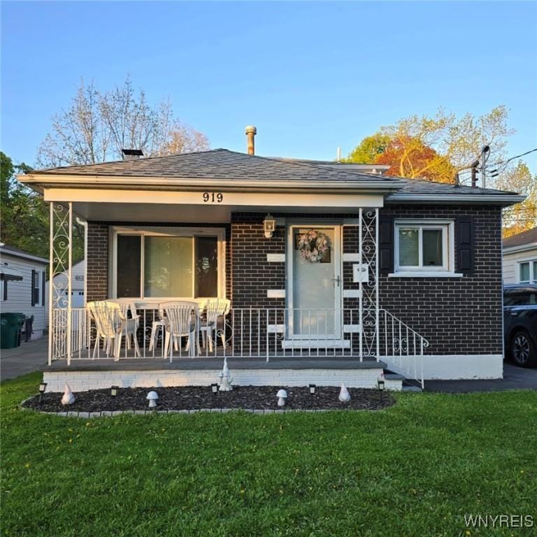 919 88th St, Niagara Falls, NY 14304 - view of front of property with brick siding, a front lawn, and a porch