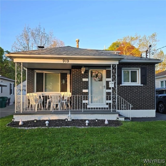 919 88th St, Niagara Falls, NY 14304 - view of front of property with brick siding, a front lawn, and a porch