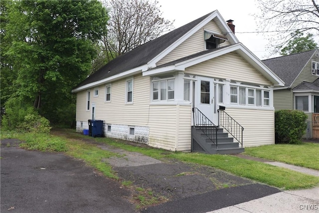 bungalow with entry steps and a chimney