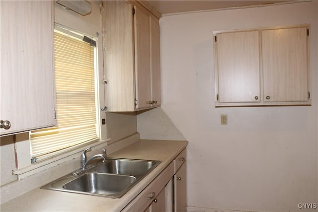 kitchen with a sink, light countertops, and light brown cabinets