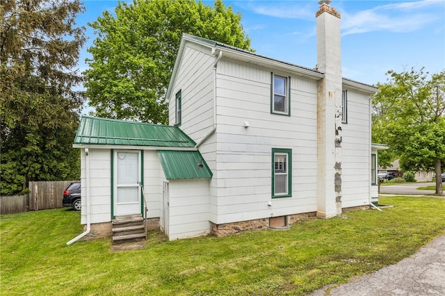 10 Clinton St, Bergen, NY 14416 - rear view of property with entry steps, a chimney, and metal roof