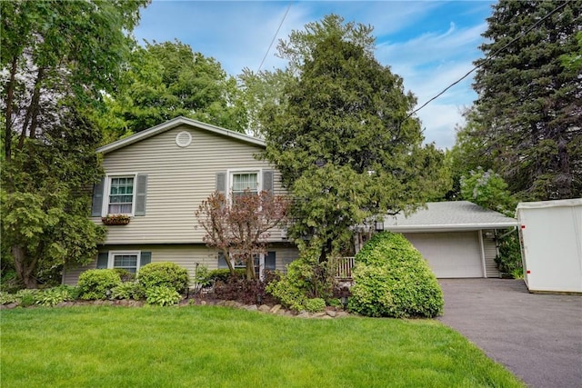 split level home featuring a front yard, a garage, and asphalt driveway
