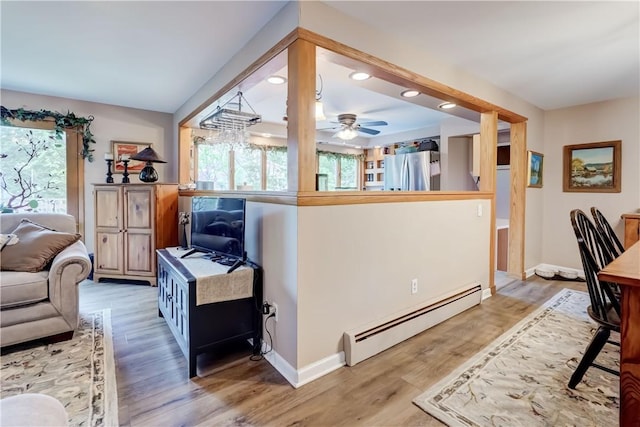 living room with a baseboard heating unit, plenty of natural light, recessed lighting, and light wood finished floors