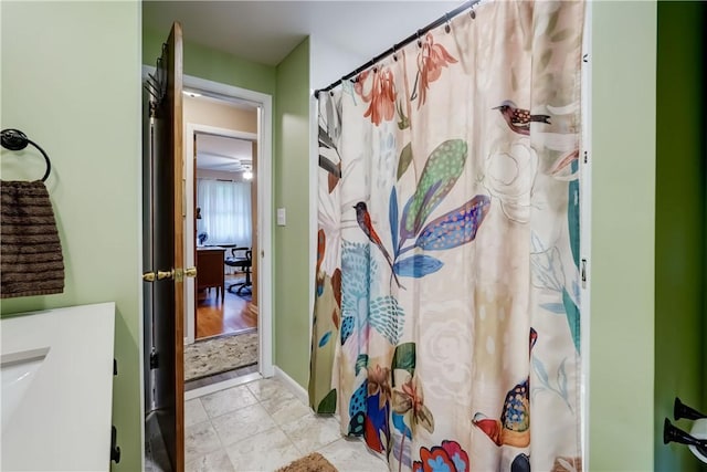 bathroom with a shower with curtain and baseboards