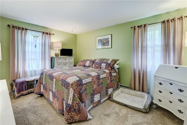 bedroom with multiple windows, carpet, and a baseboard radiator