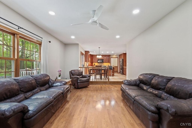 living area with light wood-style floors, a ceiling fan, and recessed lighting