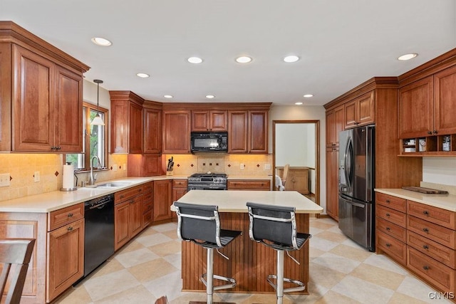 kitchen with black appliances, a sink, light floors, recessed lighting, and light countertops
