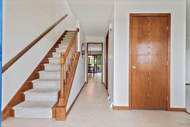 corridor with baseboards and stairway