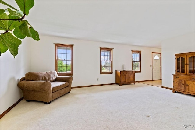living area with light carpet and baseboards