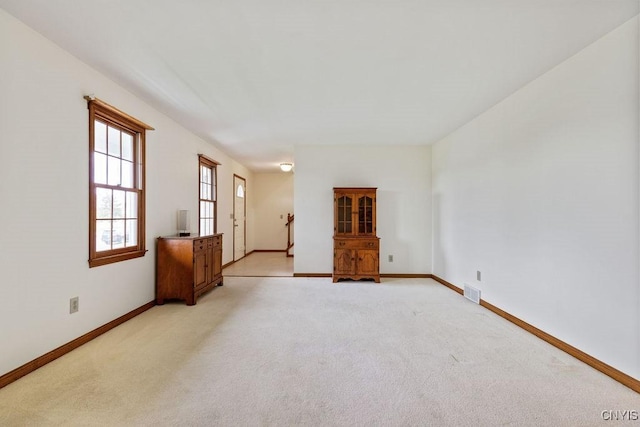 empty room with baseboards and light carpet