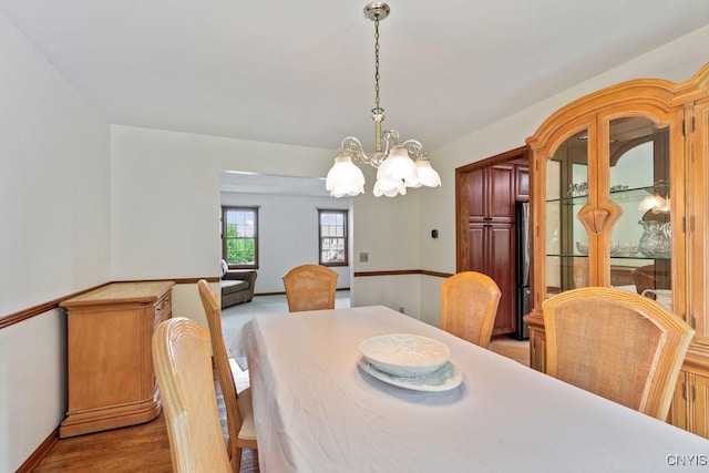dining area with a chandelier, baseboards, and wood finished floors