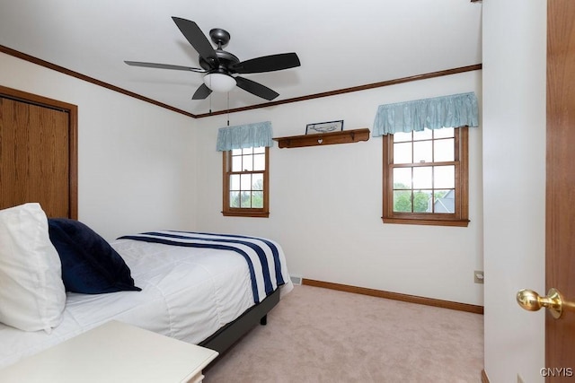 carpeted bedroom featuring multiple windows, baseboards, crown molding, and a ceiling fan