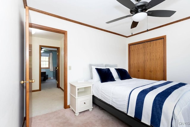 bedroom featuring light colored carpet, crown molding, ceiling fan, and a closet