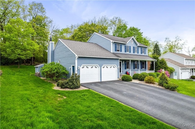 view of front facade featuring a porch, an attached garage, a front yard, and driveway