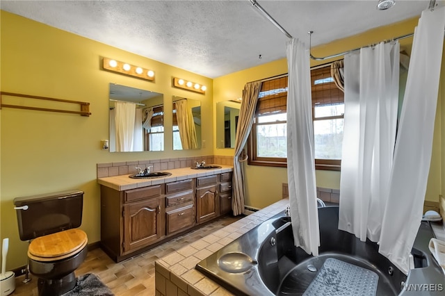 353 Campbell Rd, Sweden, NY 14420 - full bath with tasteful backsplash, toilet, a textured ceiling, double vanity, and a relaxing tiled tub
