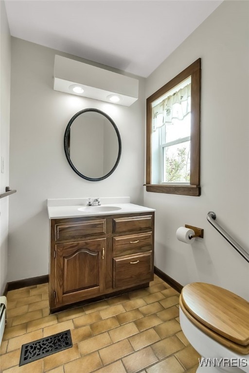 353 Campbell Rd, Sweden, NY 14420 - bathroom featuring toilet, vanity, baseboards, and a baseboard heating unit
